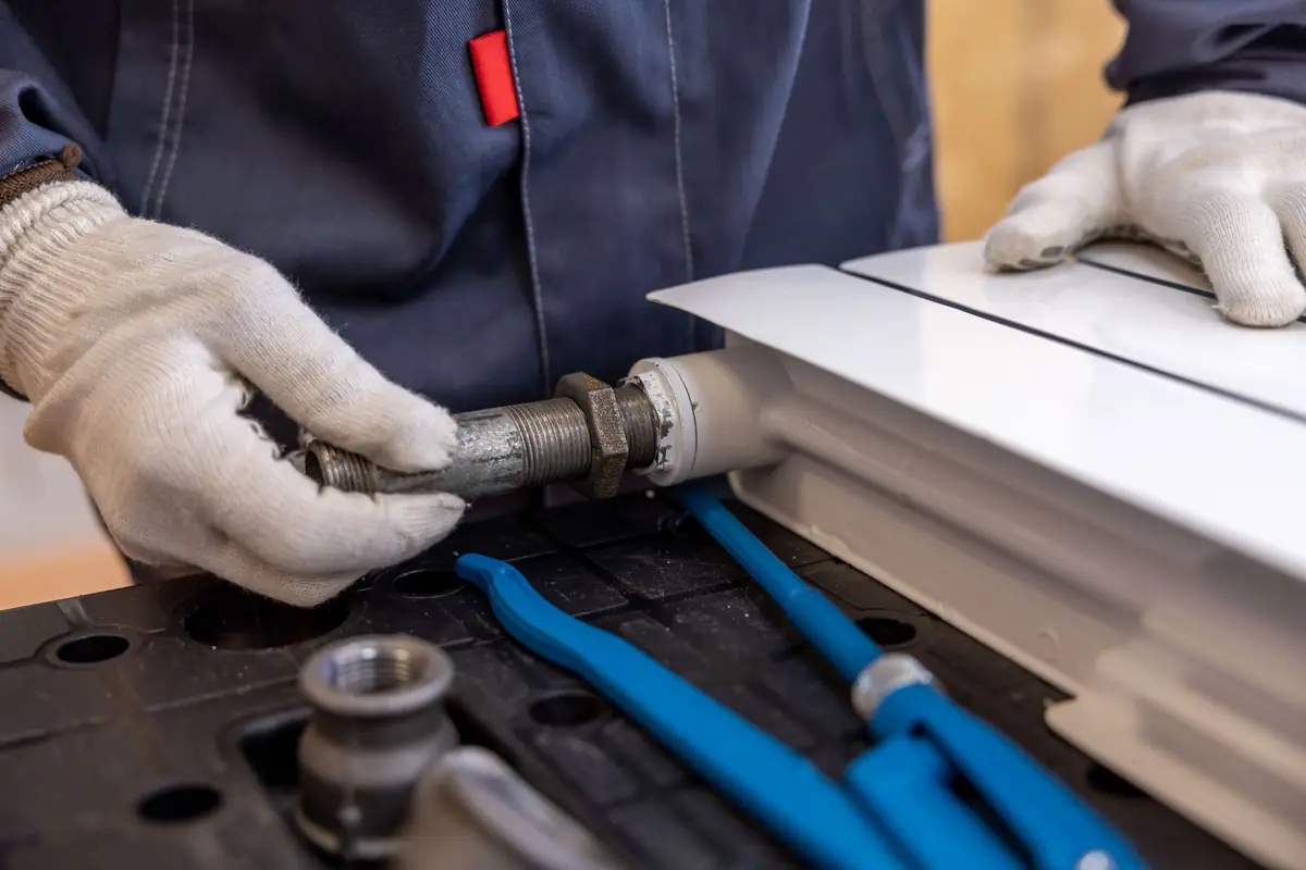 A plumber tightening a pipe fitting